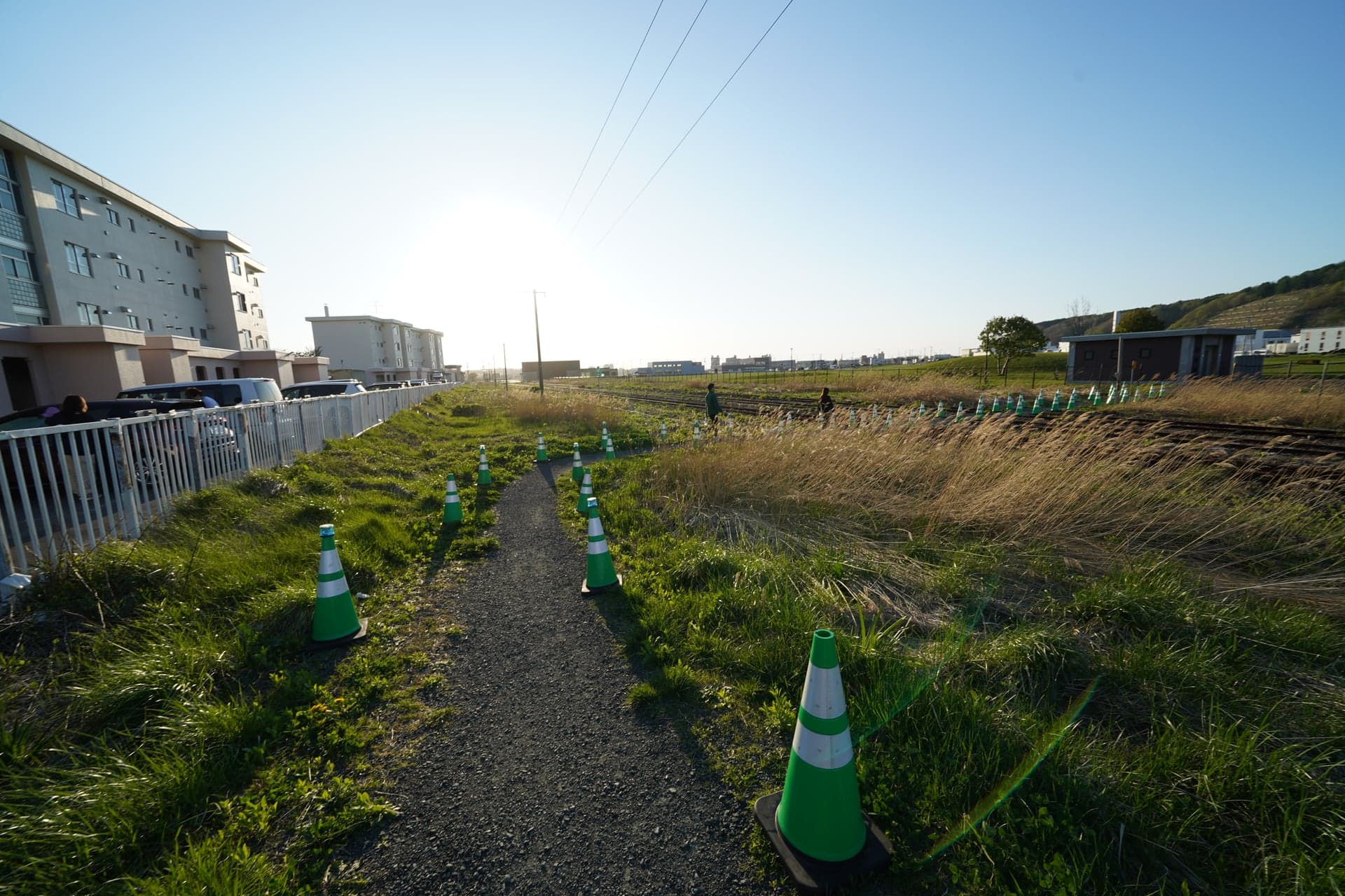 91.廃線跡に並ぶコーン、夕陽の逆光