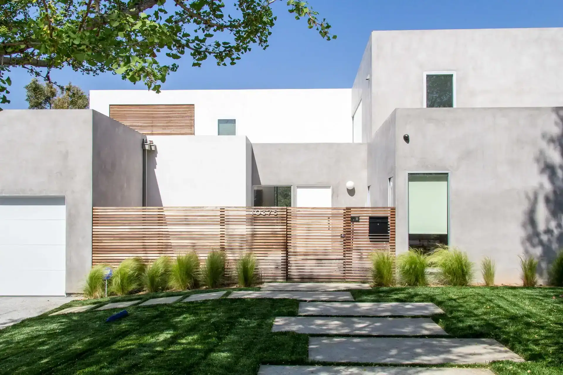 Contemporary hillside home with minimalist concrete walls, wooden fencing, and seamless indoor–outdoor flow in Los Angeles.