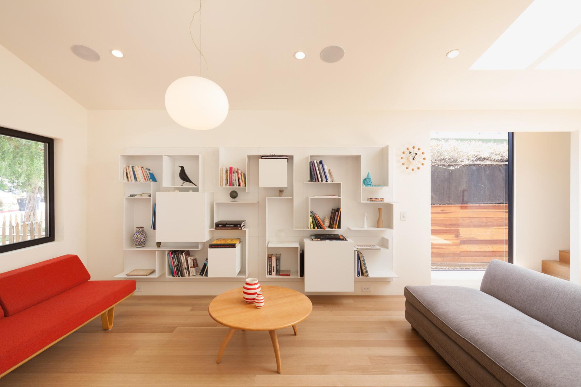 Modern living room interior with built-in shelving and minimalist decor.