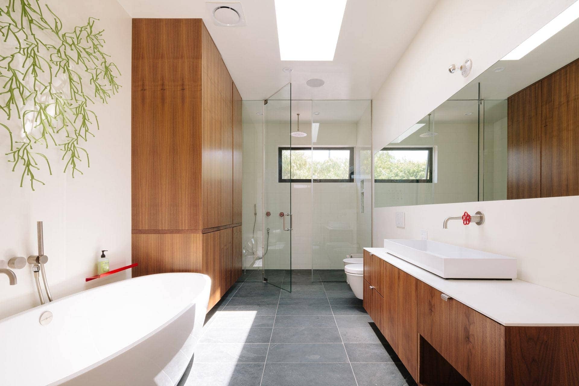 Contemporary bathroom interior with wooden accents, sleek fixtures, and glass shower enclosure.