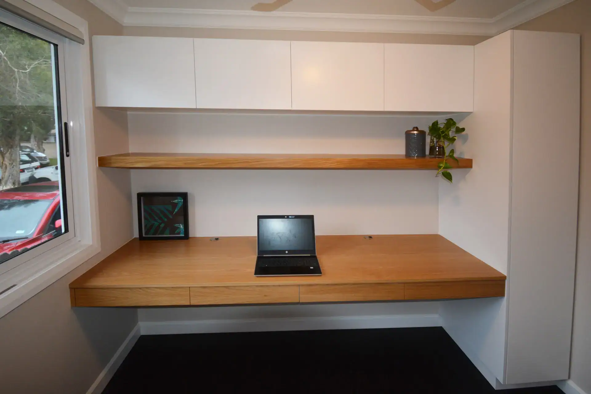 Elegant Custom Made Home Office With Free Floating Desk And Shelf Boustead and Brown designed and built this elegant built-in home office optimized for productivity. The extensive American white oak veneer desktop and shelf are the focal point, finished in a clear satin that highlights the oak's organic warmth. For task lighting, an LED strip discreetly lights the underside of the shelf. The cabinetry provides storage space for files and supplies behind the Blum's soft-close doors, and integrated drawers built into the free-floating desk offer additional concealed storage for pens and other stationery. The final result of this custom-made home office is a beautiful balance of warm materials, functionality, and storage.