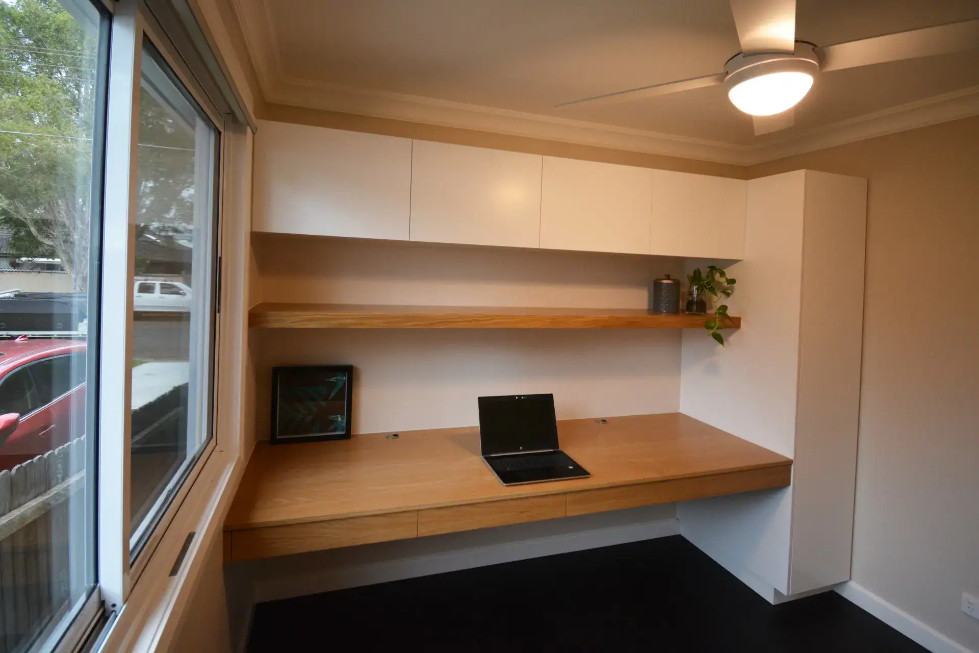 Elegant Custom Made Home Office With Free Floating Desk And Shelf Boustead and Brown designed and built this elegant built-in home office optimized for productivity. The extensive American white oak veneer desktop and shelf are the focal point, finished in a clear satin that highlights the oak's organic warmth. For task lighting, an LED strip discreetly lights the underside of the shelf. The cabinetry provides storage space for files and supplies behind the Blum's soft-close doors, and integrated drawers built into the free-floating desk offer additional concealed storage for pens and other stationery. The final result of this custom-made home office is a beautiful balance of warm materials, functionality, and storage.