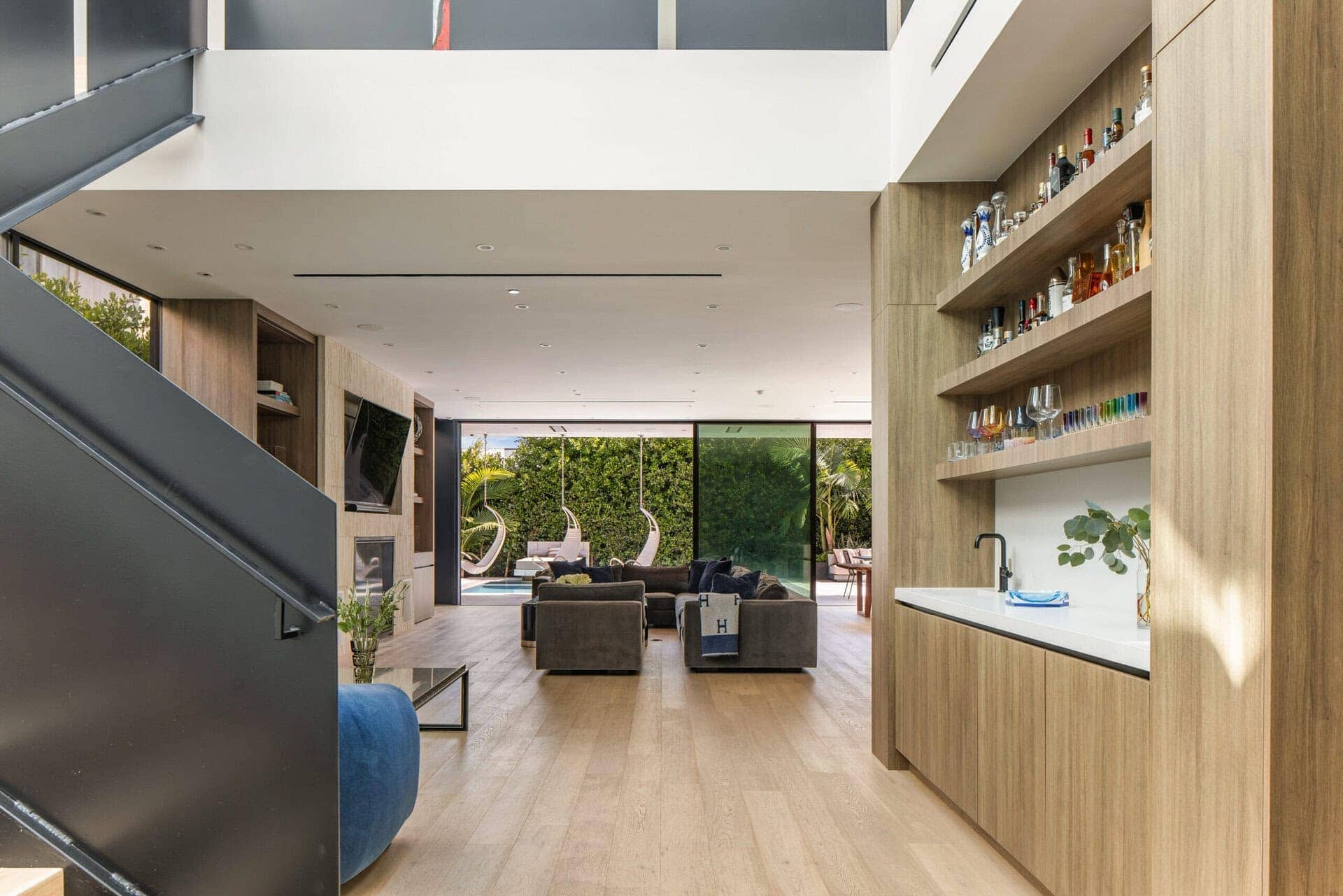 Contemporary open-concept living space with sleek wood paneling, natural light, and modern furnishings.