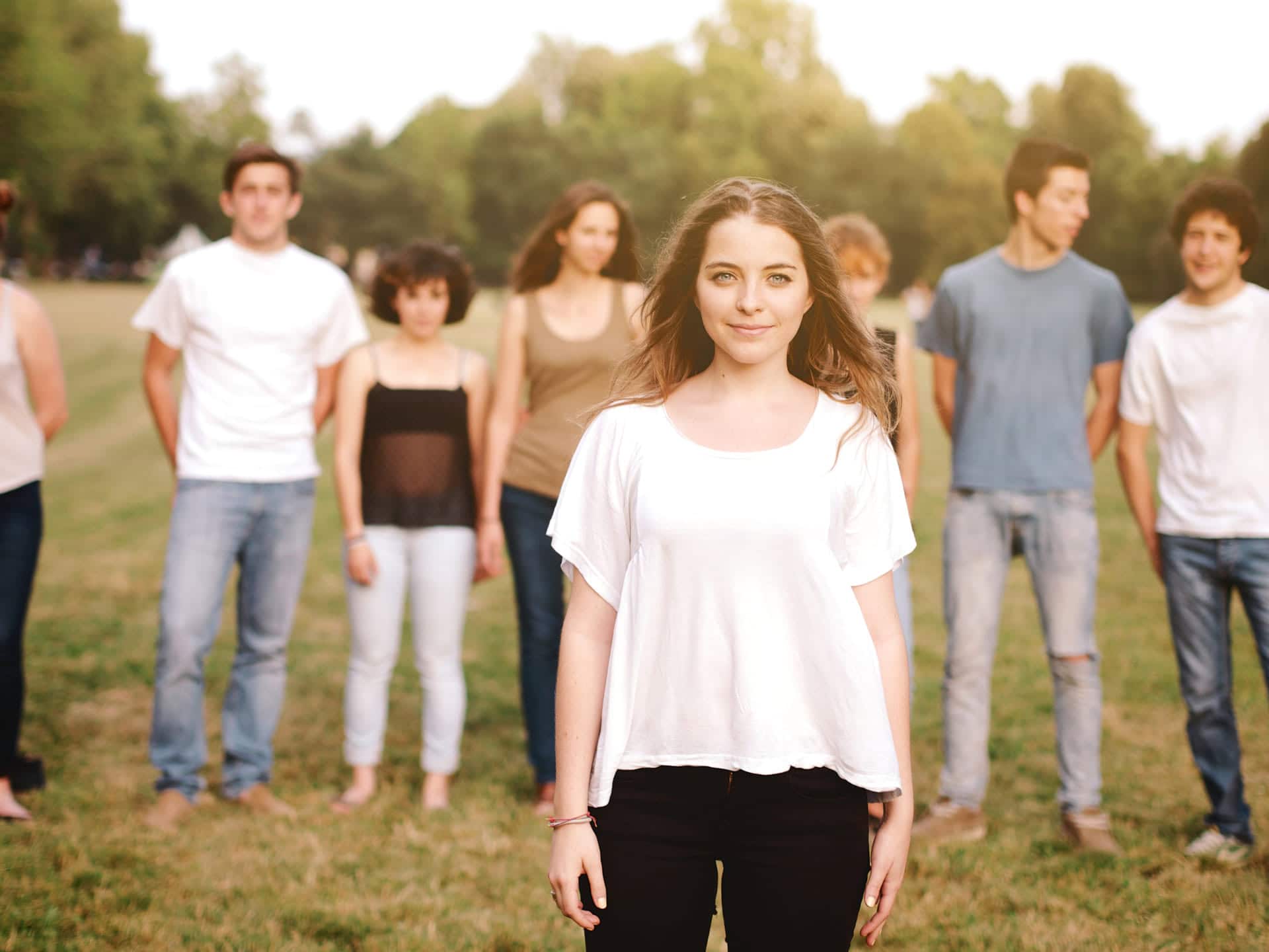 Mujer joven al frente a un grupo de personas en entorno natural