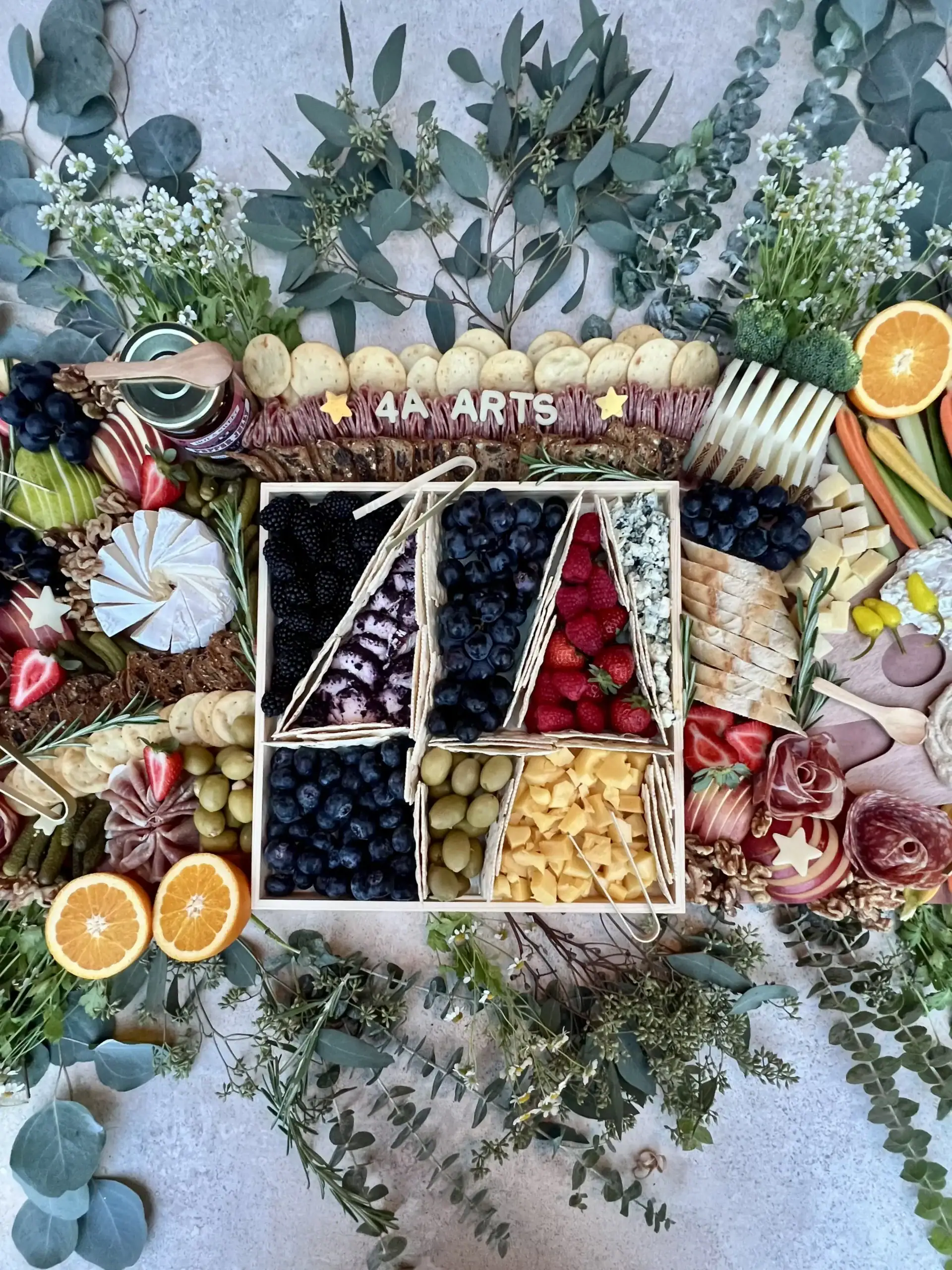 An elaborate charcuterie board in the shape of the 4A Arts logo