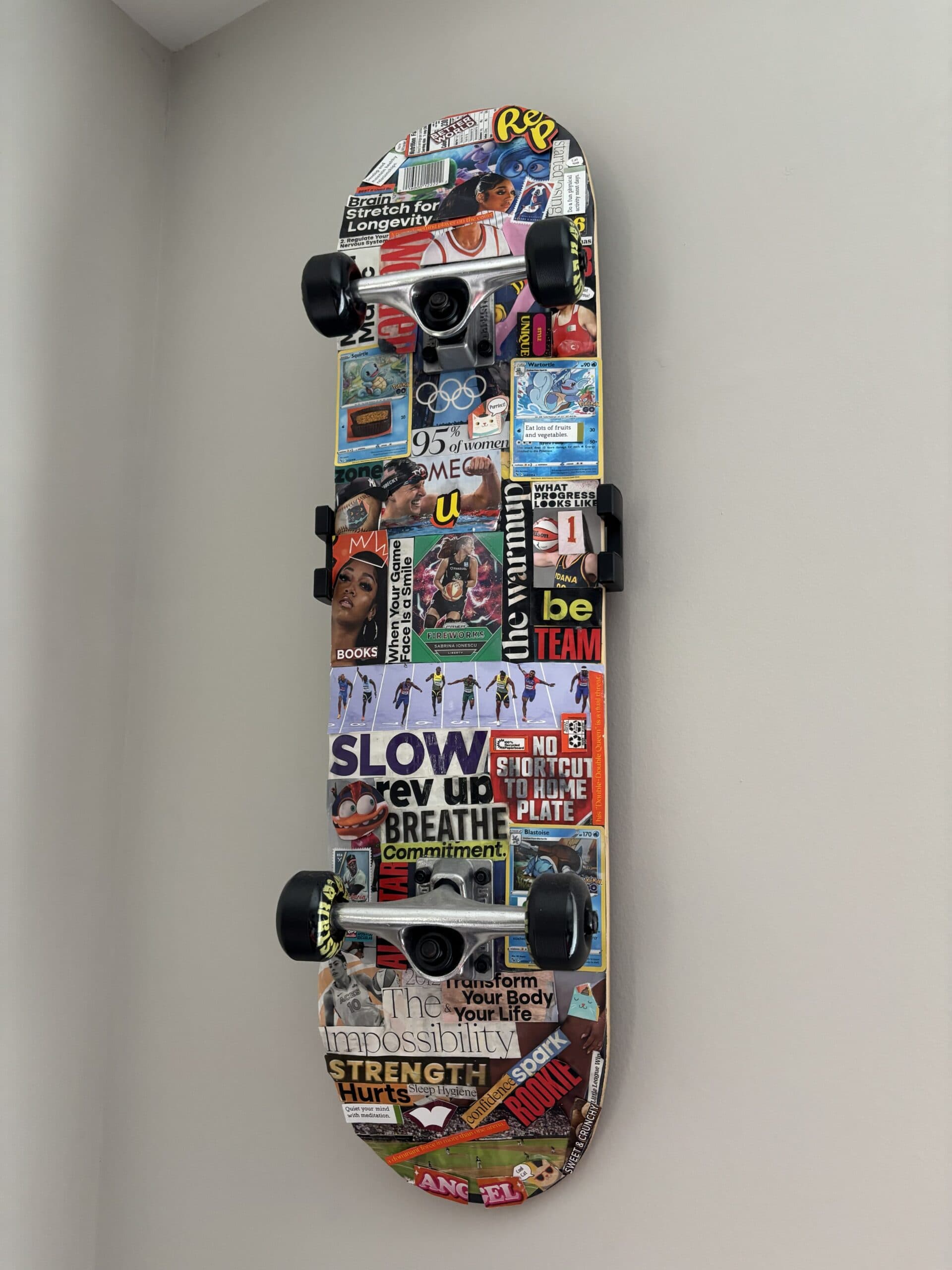 A custom skateboard created by Dr. McCabe featuring a collage of images, cards, and cutouts representing the psychology of sport.