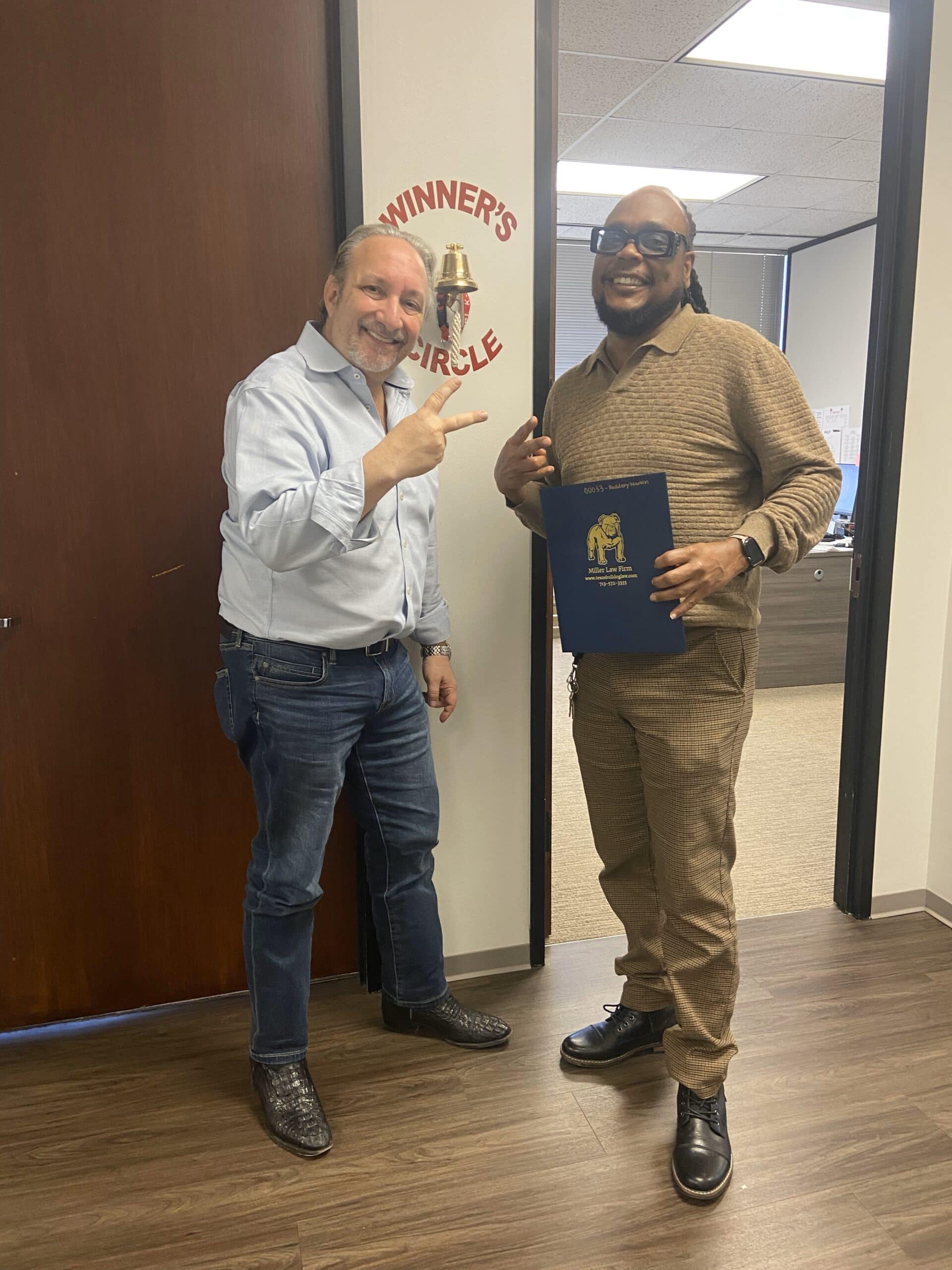 Victorious client smiling beside The Texas Bulldog after resolving their case.