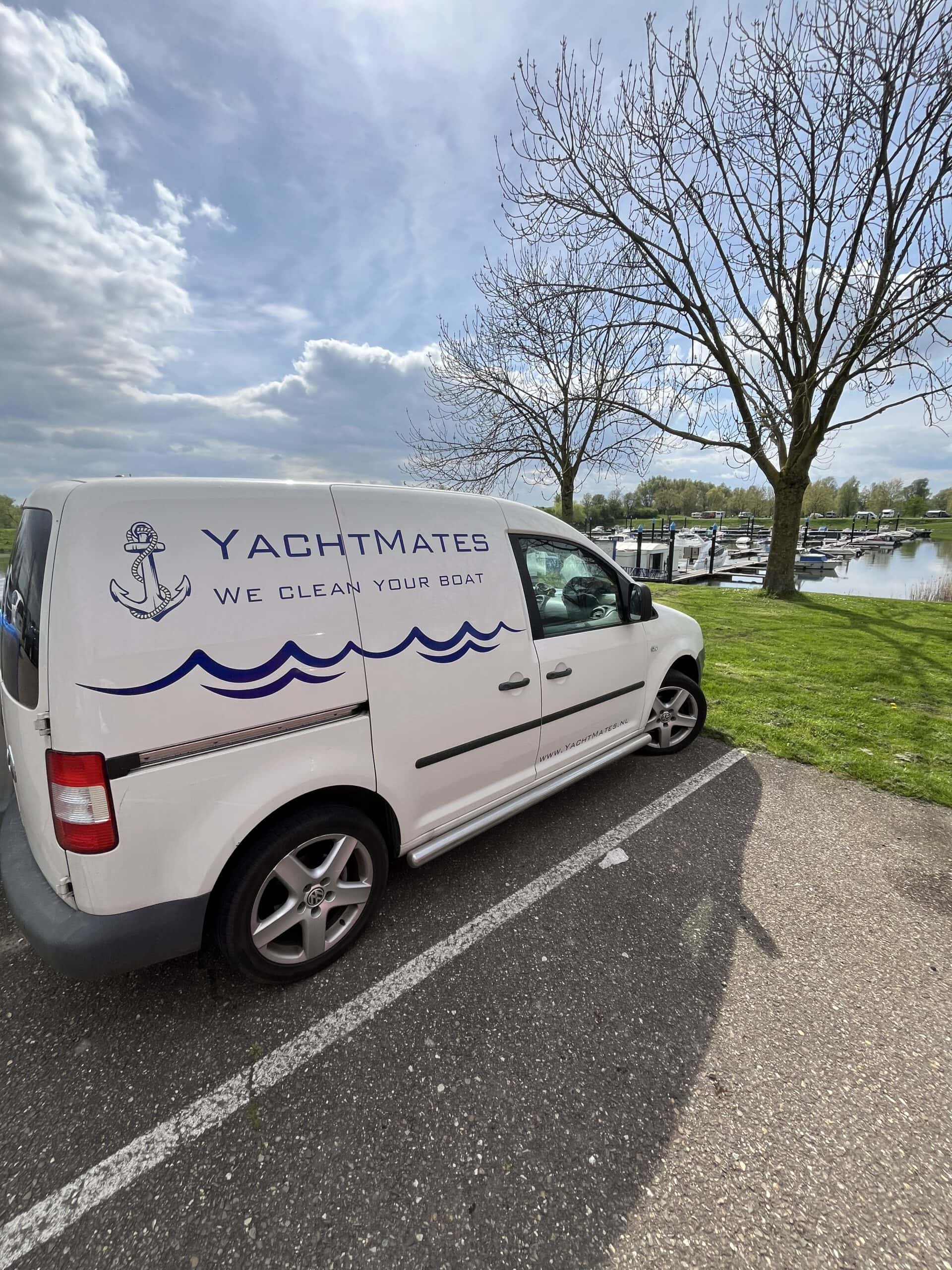 De bedrijfsbus van YachtMates, voorzien van een bedrijfslogo en kleurenschema, geparkeerd op een locatie