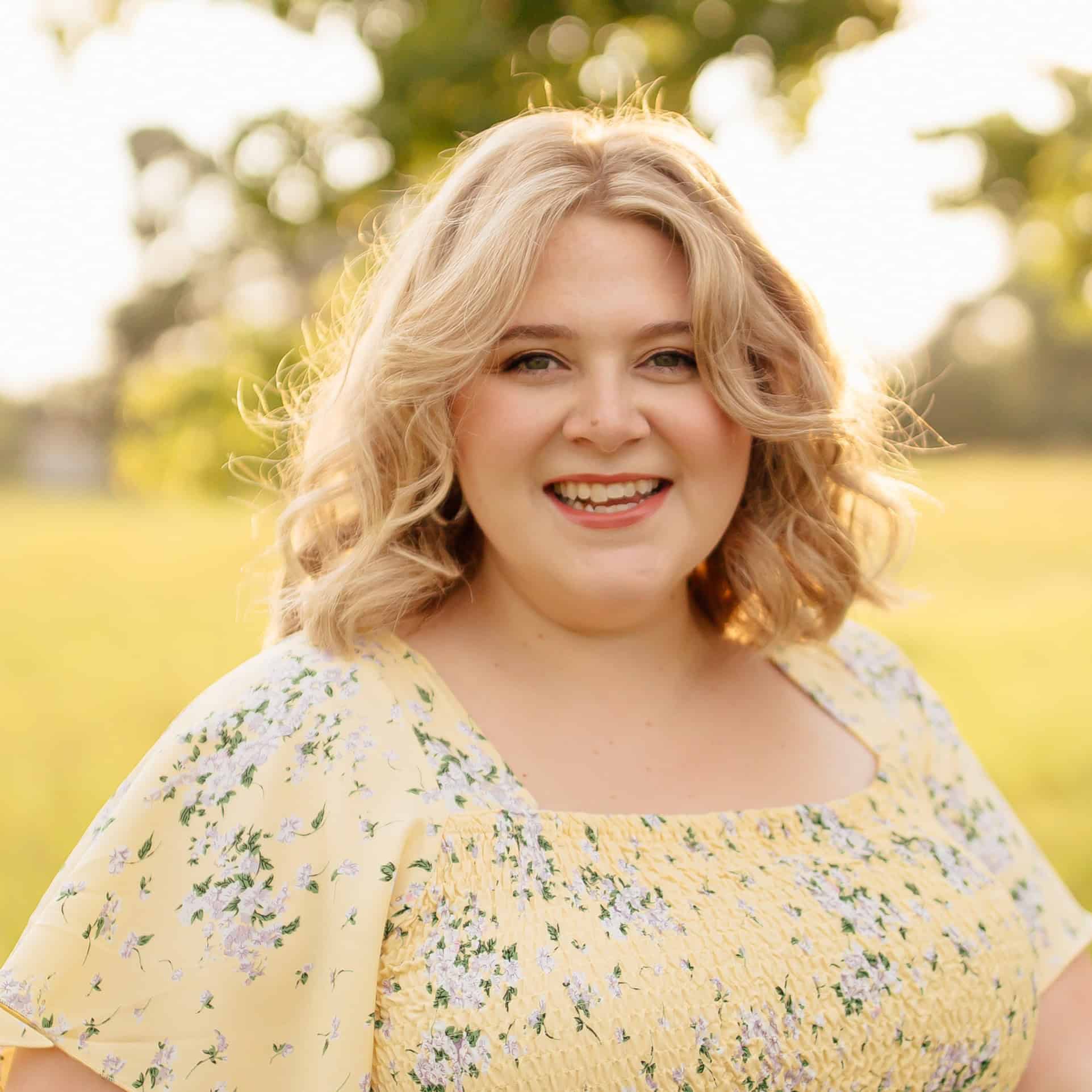 Portrait of Lara Thompson smiling outdoors in natural sunlight.
