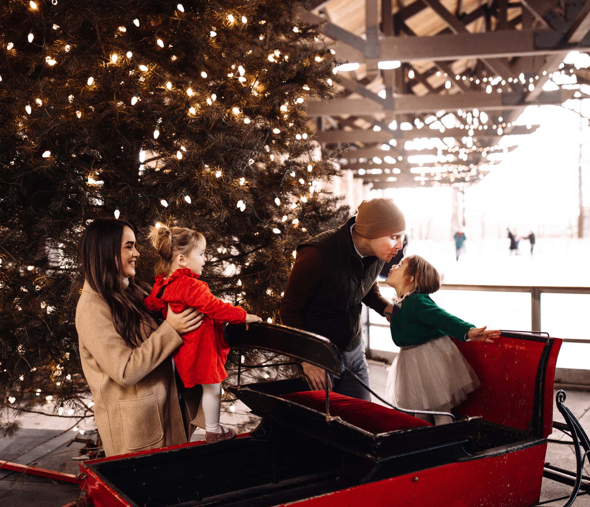 Family Posing Around a Sled Near Our Outdoor Ice Skating Pavilion