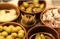 Antipasti tipici della Basilicata in ciotole di terracotta, con olive, cipolline, salame e sott’oli, da Stigliano