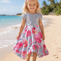 Girl at the beach wearing SIZE 4 Girls high-low Zinnia ruffle skirt in Pink Flowers