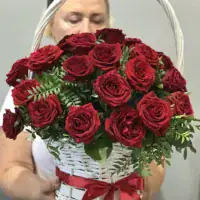 Klasyczny bukiet róż w koszu z czerwonymi różami i ozdobną wstążką