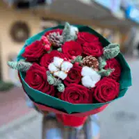 Bukiet róż w stylu bożonarodzeniowym z czerwonymi różami i leśnymi ozdobami