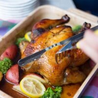 Hands carving sweet tea brined chicken