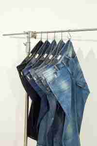 five pairs of jeans hanging on a clothes rack  representing how online therapy is not "one size fits all"