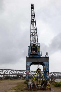 Hafenkran, im Hintergrund eine Eisenbahnbrücke