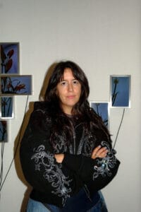 Portrait of artist Julieta Tarraubella standing in front of her audiovisual flower installation.