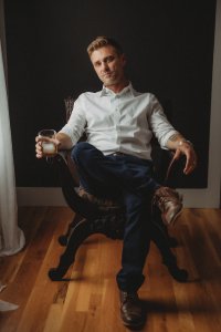 author photo, seated with a drink