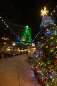 A festive Christmas tree decorated with colorful ornaments and lights at Basin Park, Eureka Springs.