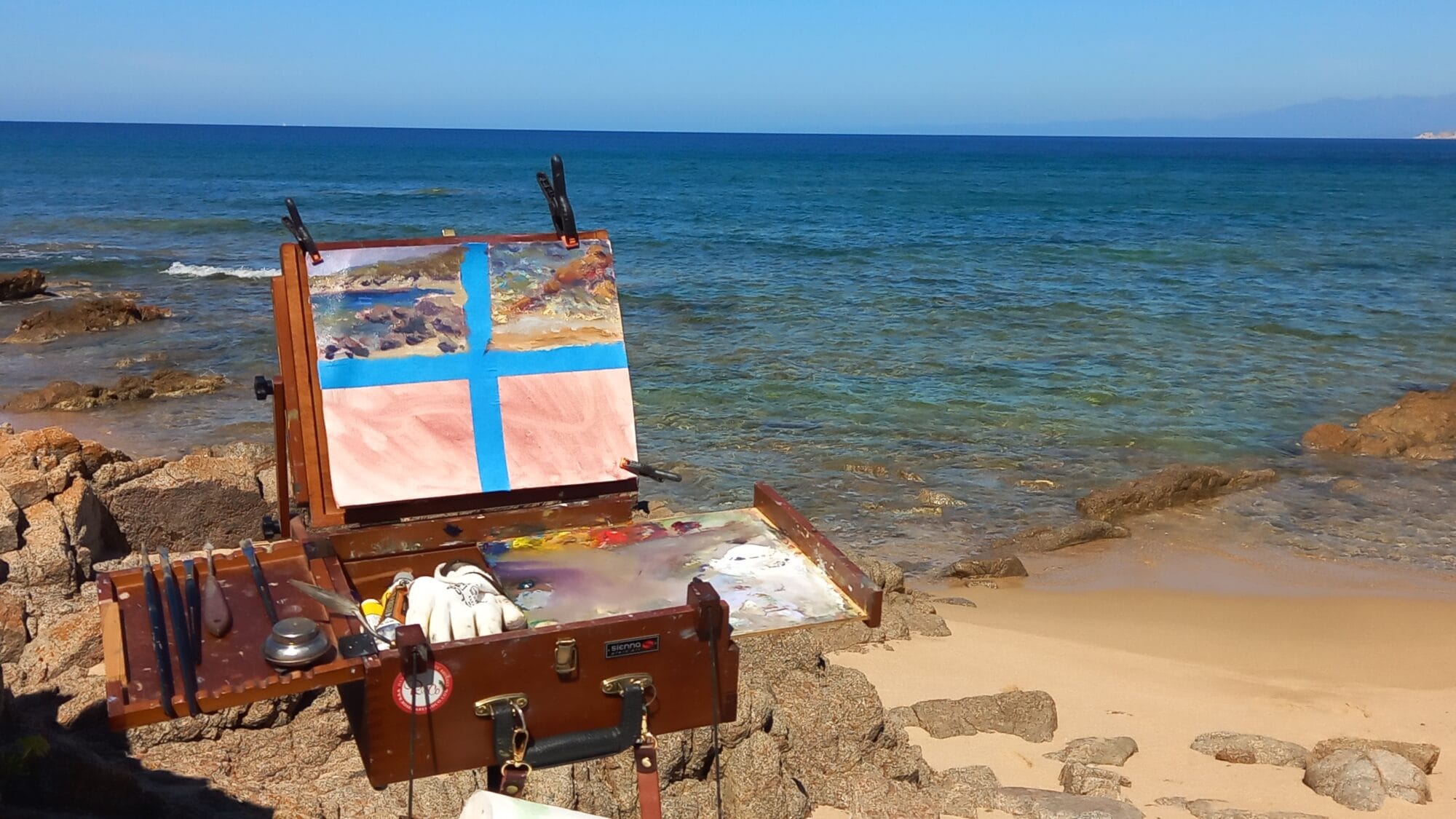 Painting on the Sardinian coast during a plein air session with a portable pochade box overlooking the Mediterranean Sea.