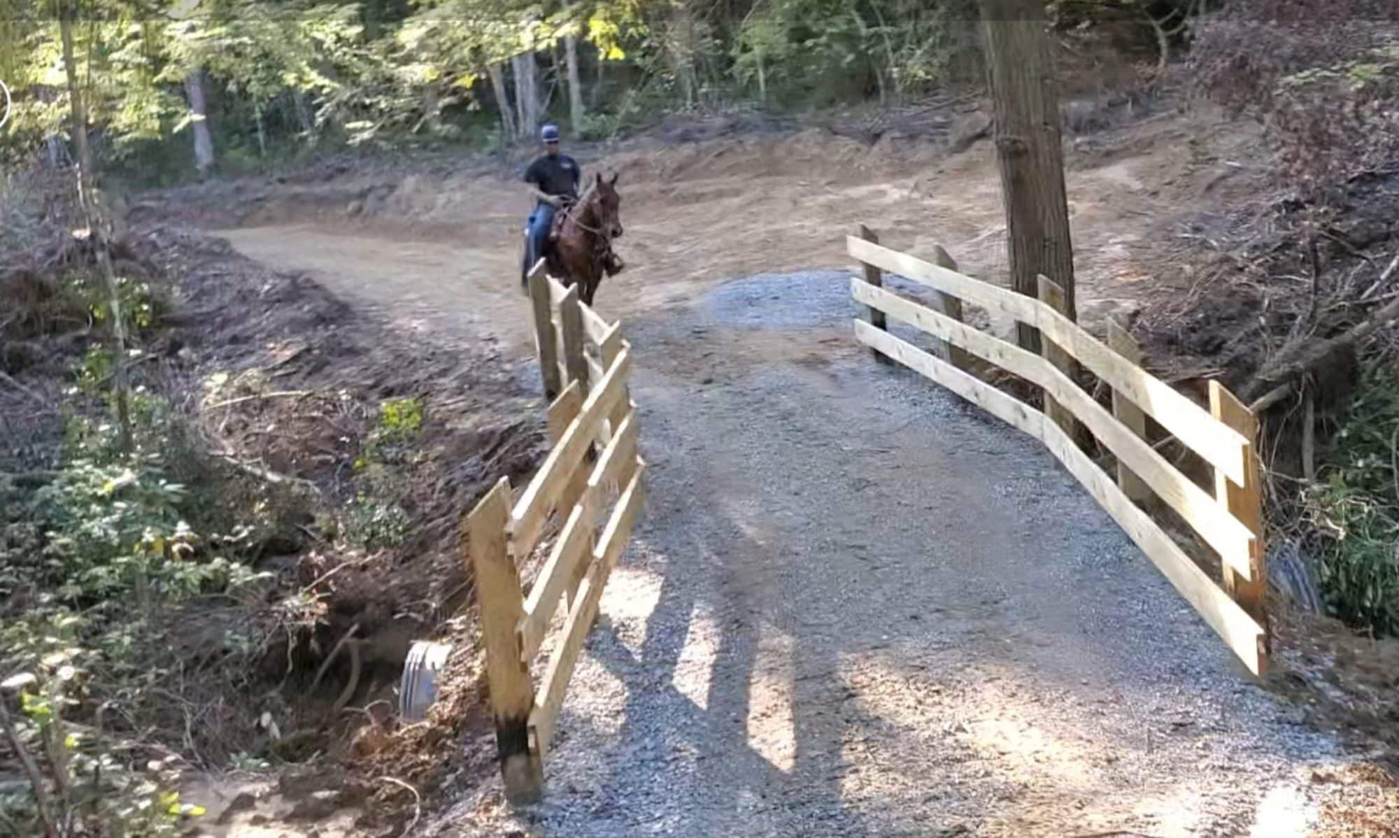 Rider crossing bridge on trail