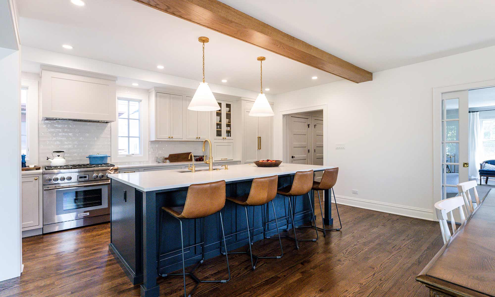 Luxury remodel and kitchen island with white and blue cabinets and white quartz countertops