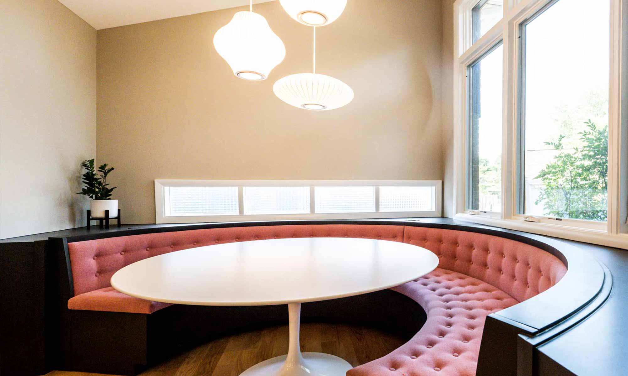 view of expansive windows above round pink booth seating