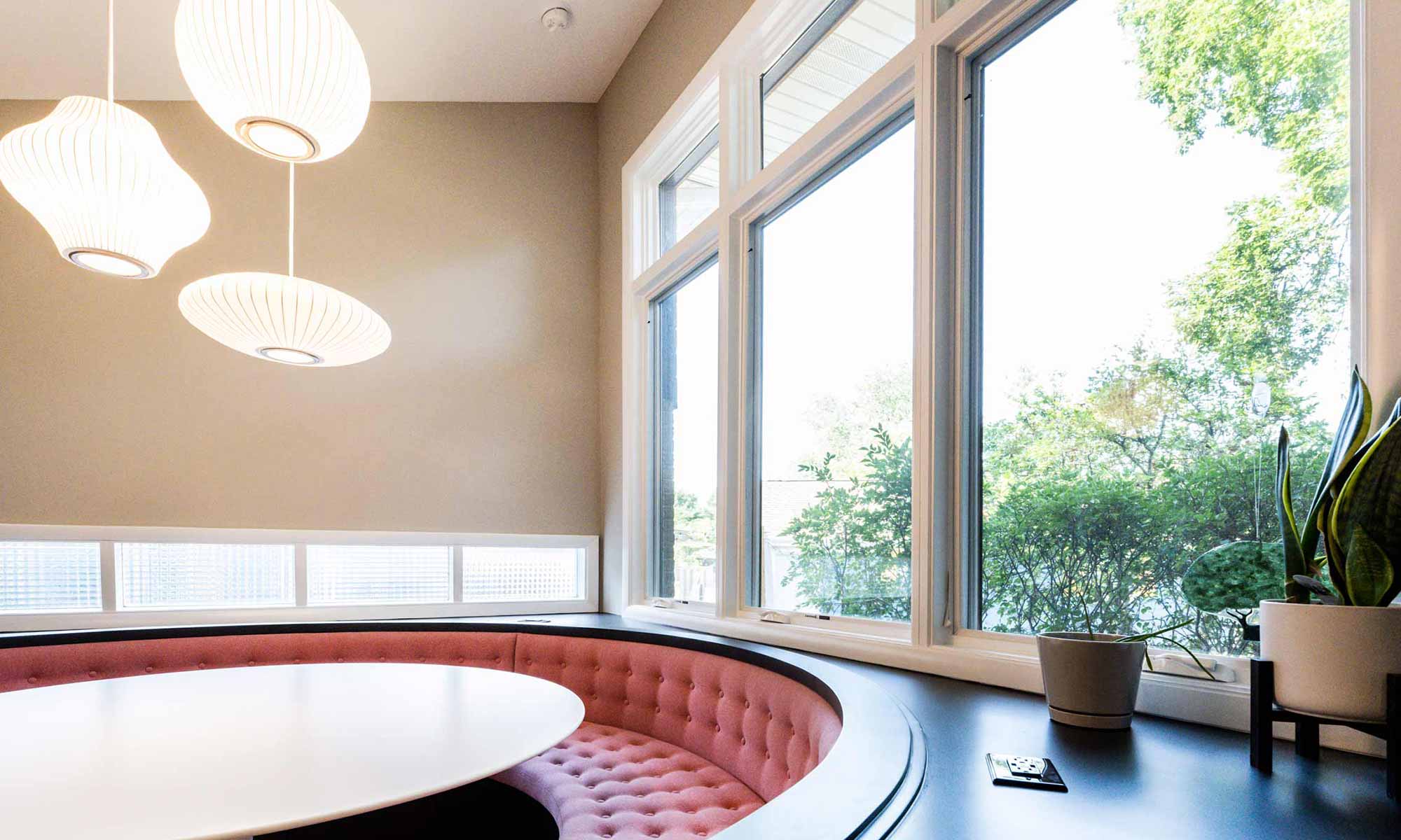 view of expansive windows above round pink booth seating