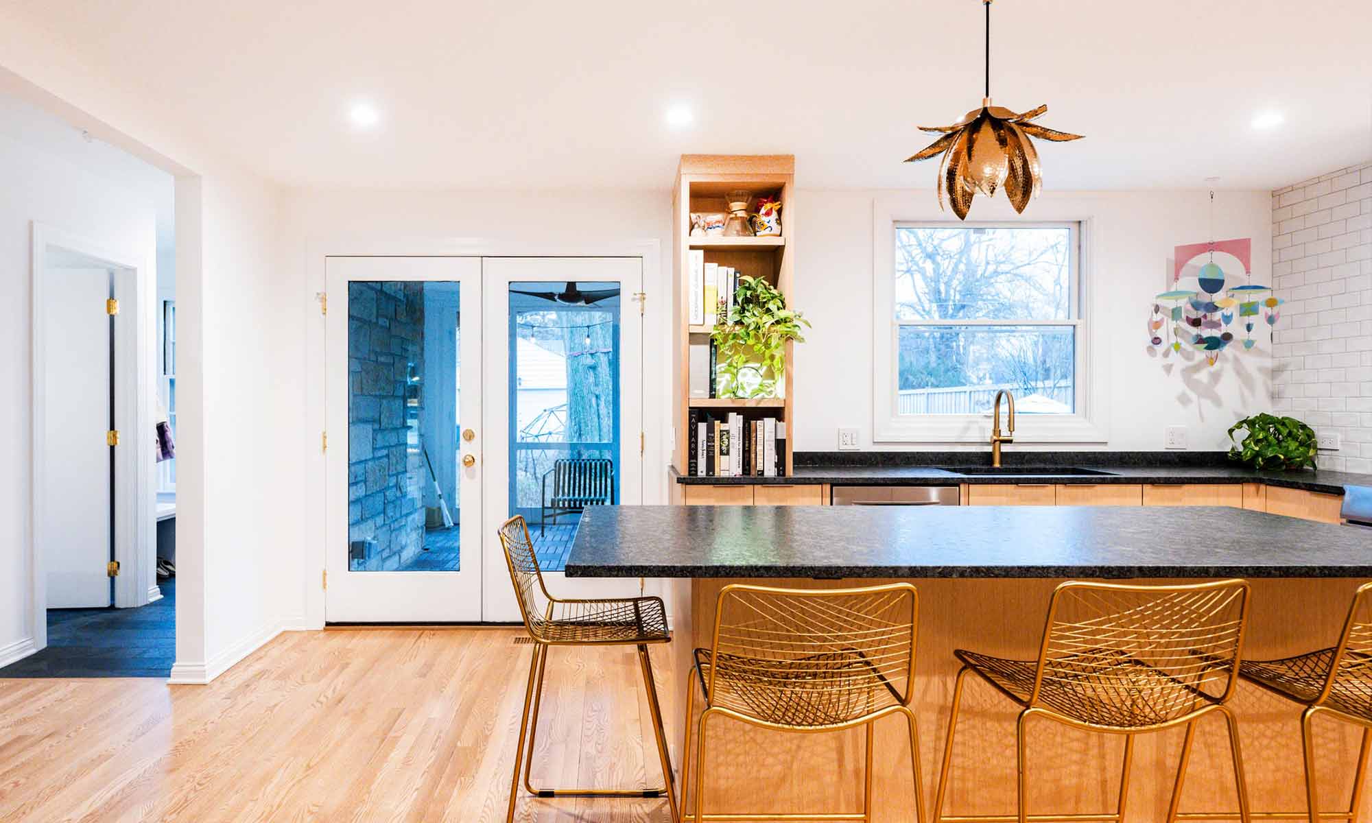 Modern luxury kitchen remodel in Riverside, IL with white oak cabinets and black stone countertops and open shelves with plants