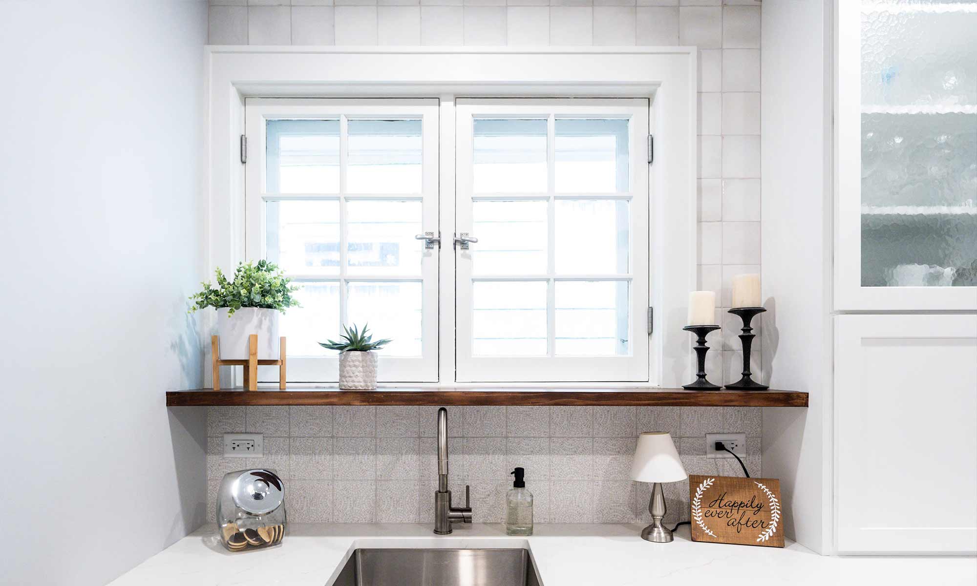 white cabinets at breakfast bar with open wood shelf and window over the sink