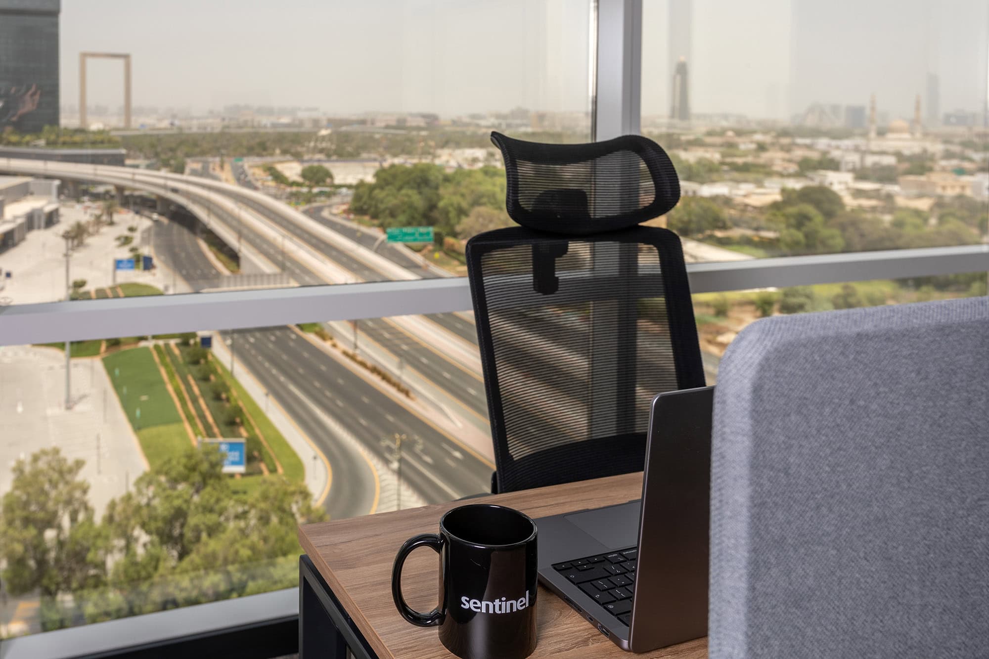 Workspace desk with coffee mug and city view in modern office