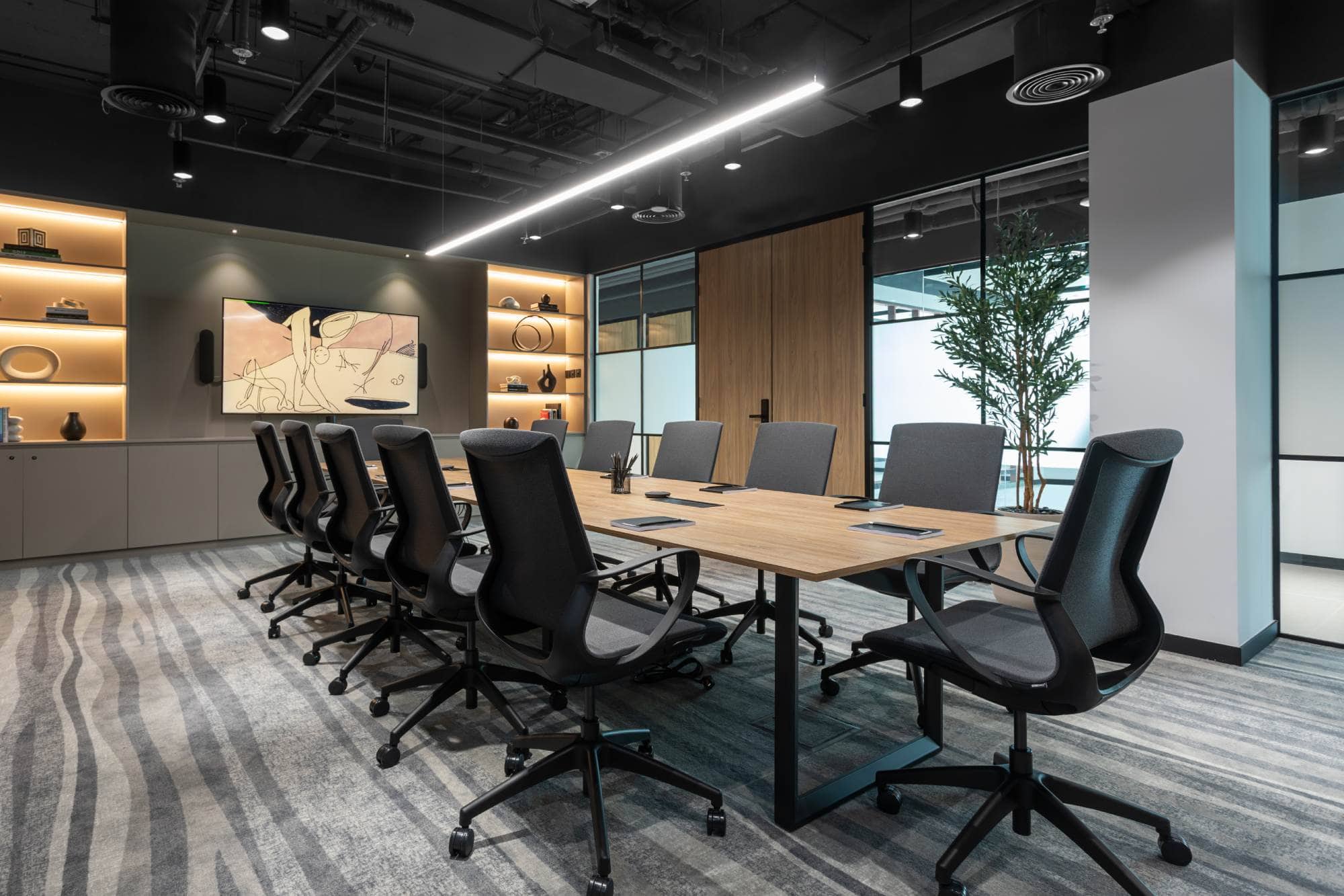 An elegant and spacious boardroom within the Sentinel Dubai co-working space, featuring a long wooden conference table, ergonomic black seating, and high-end integrated technology for professional corporate meetings.