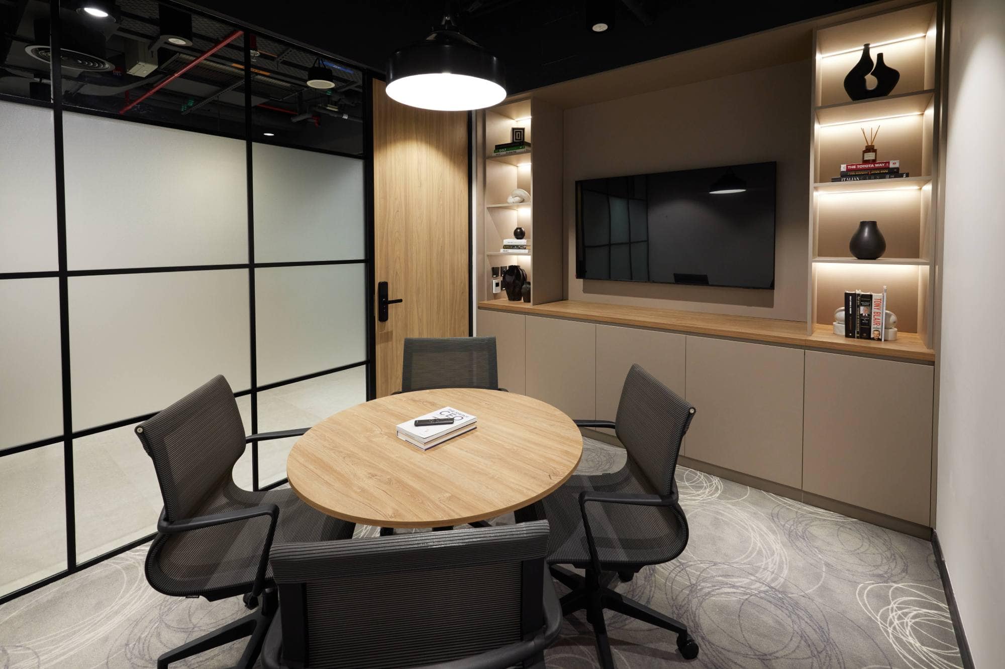 A cozy, circular meeting pod at Sentinel Dubai co-working space, perfect for private consultations and small team huddles, equipped with comfortable seating and ambient shelf lighting.