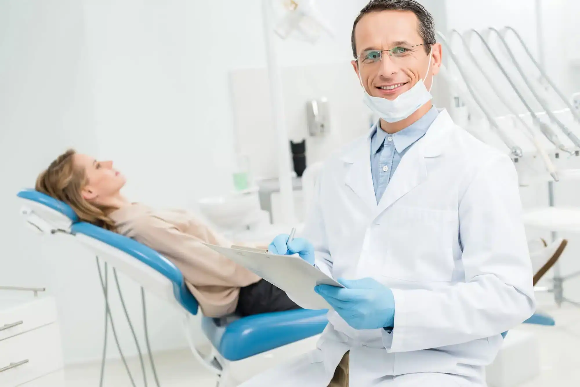 Doctor completing patient health checklist before tooth extractions in Riverview, MI