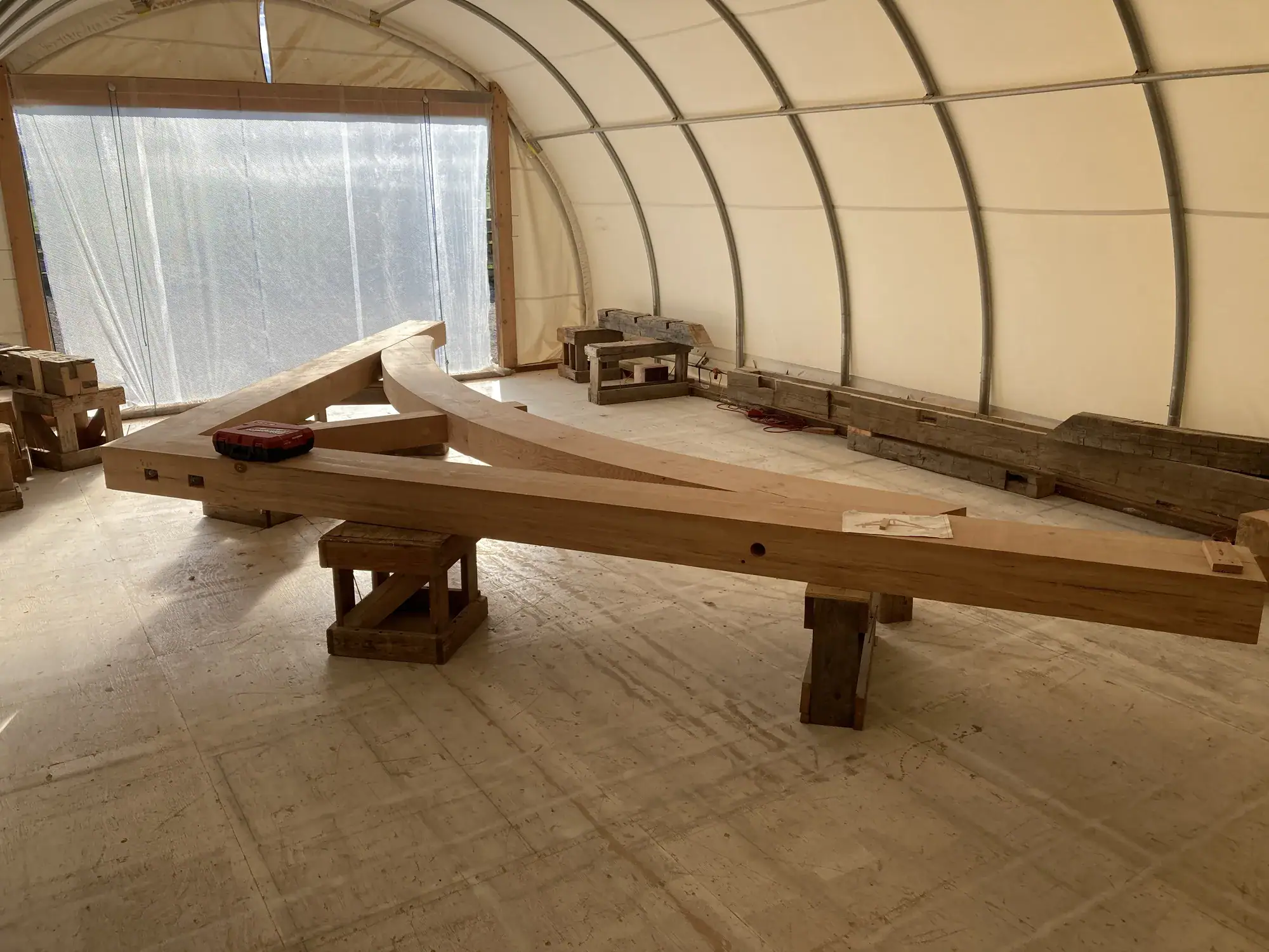 Curved timber chords on trestles inside the fabrication shop