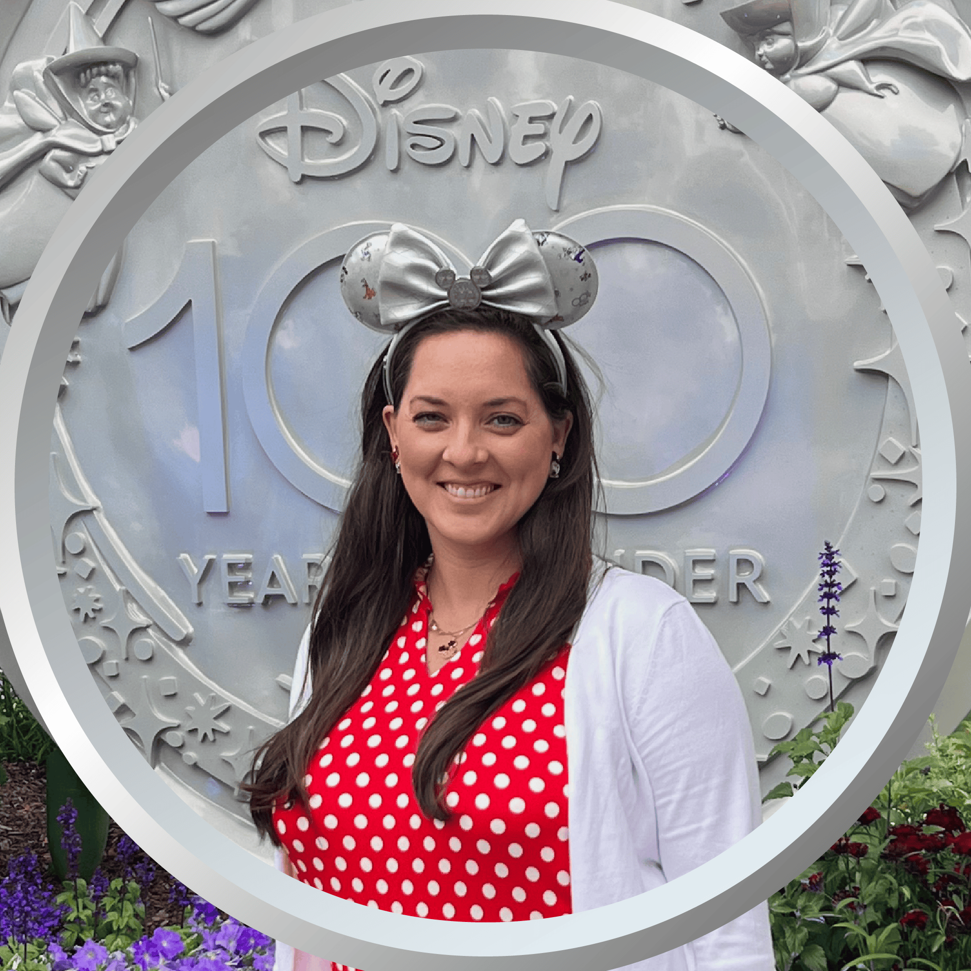 Disney 100th anniversary celebration, woman wearing Minnie Mouse ears and red polka dot dress.