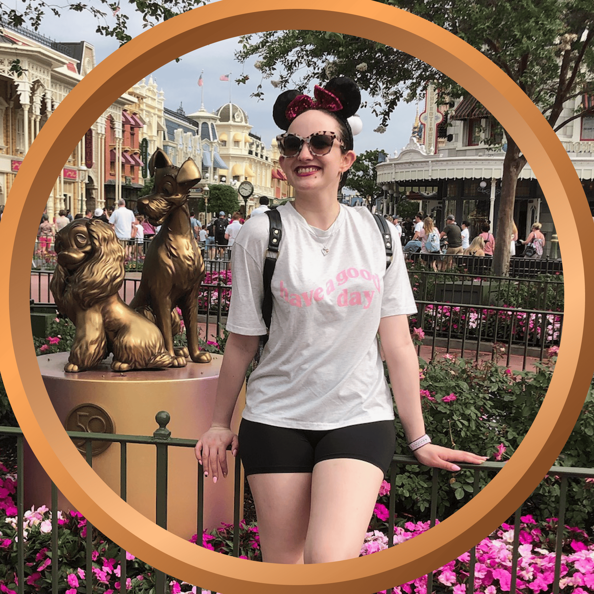 Cute woman at Disneyland wearing Minnie Mouse ears, smiling near the iconic park statues.