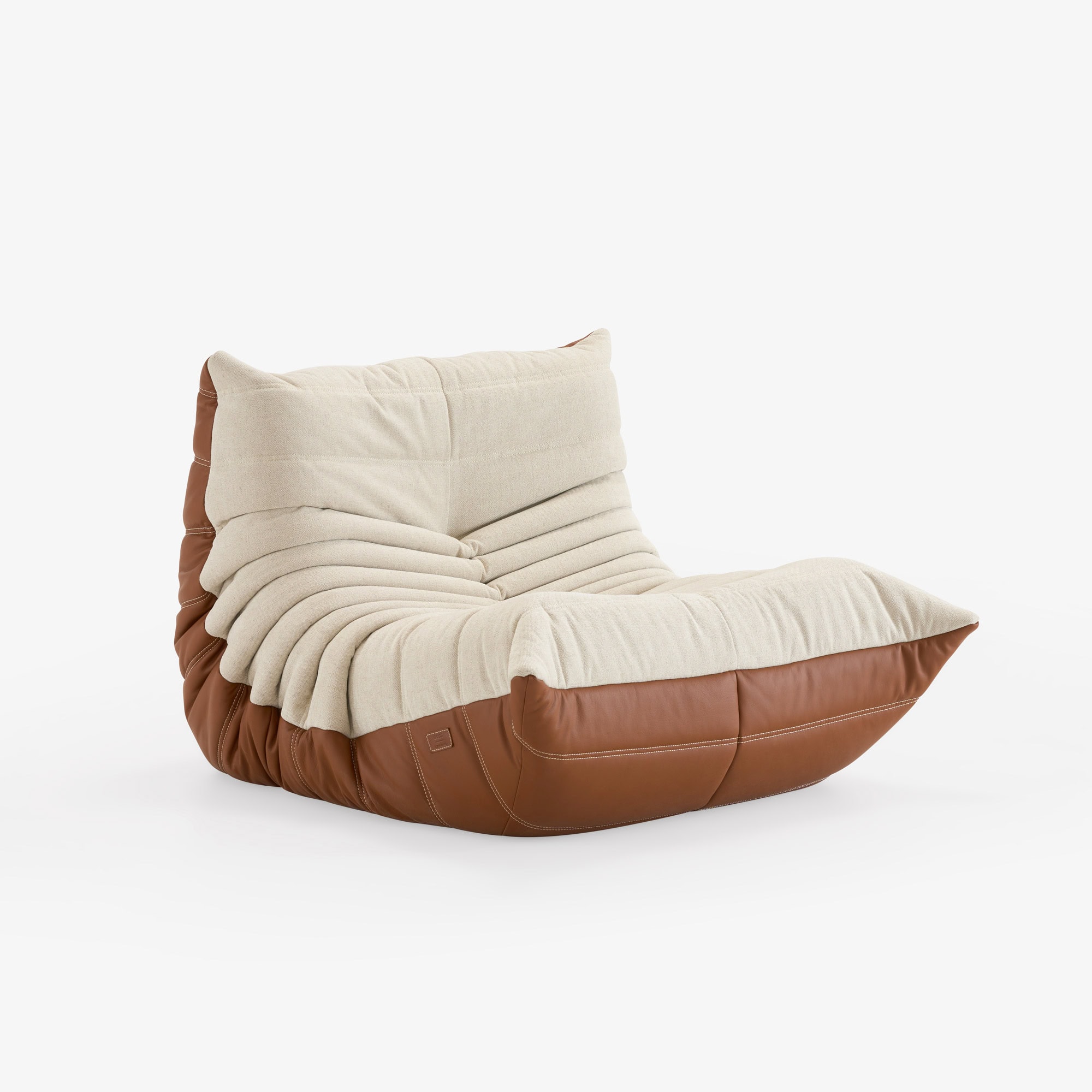 BOSS × Ligne Roset Togo fireside chair in grège textile and hazelnut leather, viewed from an angle.