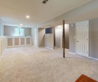 Bright, clean modern basement with recessed lighting and plush carpet flooring, ideal for a spring renovation in Ontario