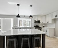 A bright, elegant modern kitchen with a marble island and sleek stainless steel appliances, ready for renovation.