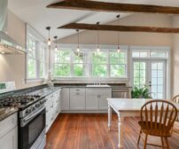 Bright kitchen interior with wooden beams and white cabinetry, natural lighting modernizing a Kitchener, Ontario renovat
