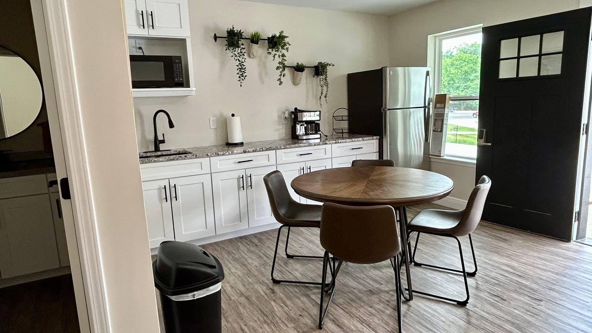 Cottage kitchenette with dining table and appliances at Romaine Valley Weddings & Events in Fenton, Missouri