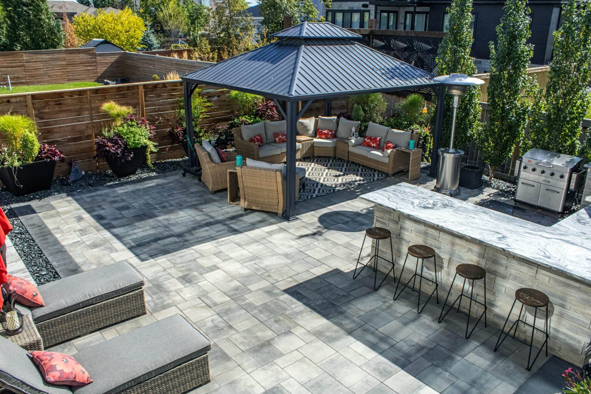 Modern outdoor patio design at Tuxedo Terrace with seating area, landscaping, and stone features build by Lawn N Order professinoal landscaping contractor