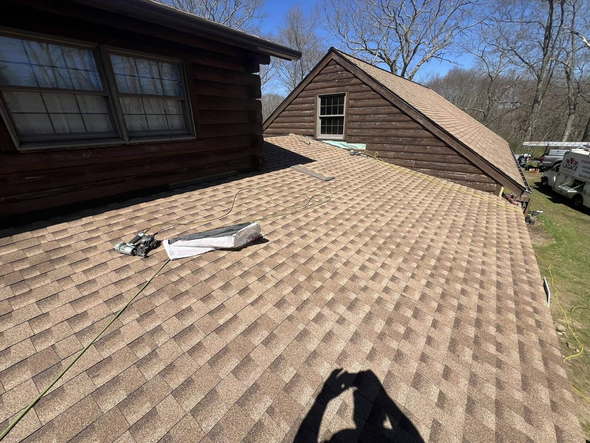 New shingle roof installed by Lagace Construction on a residential log cabin in Andover, CT