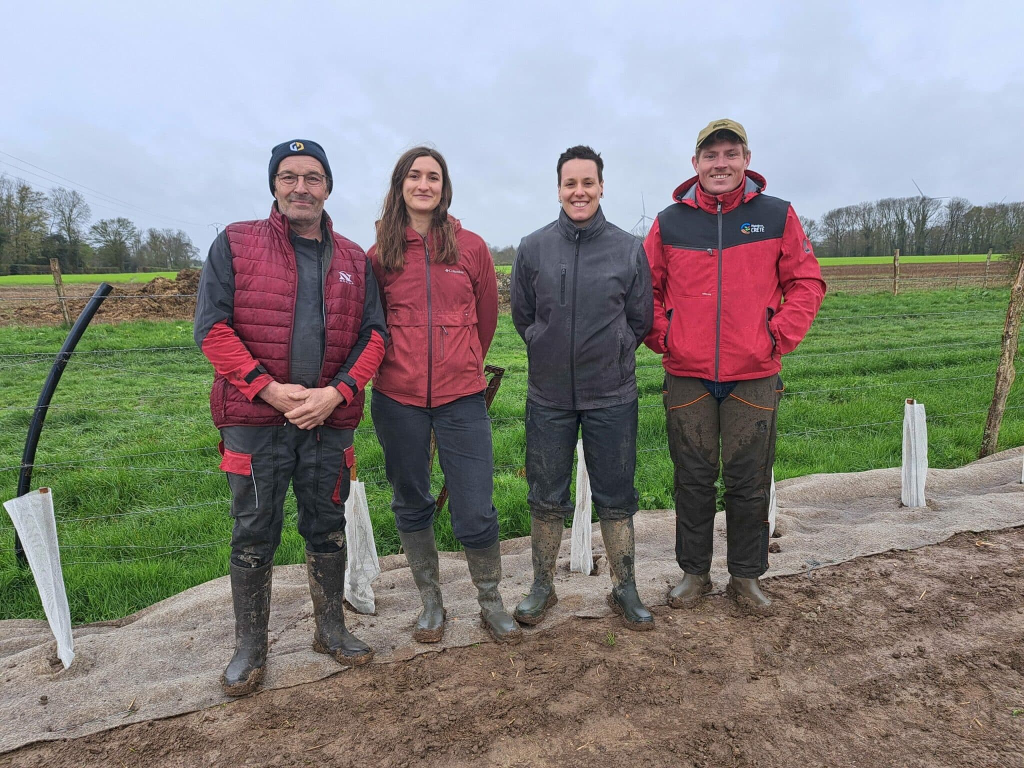 Quatre personnes devant une plantation de haies