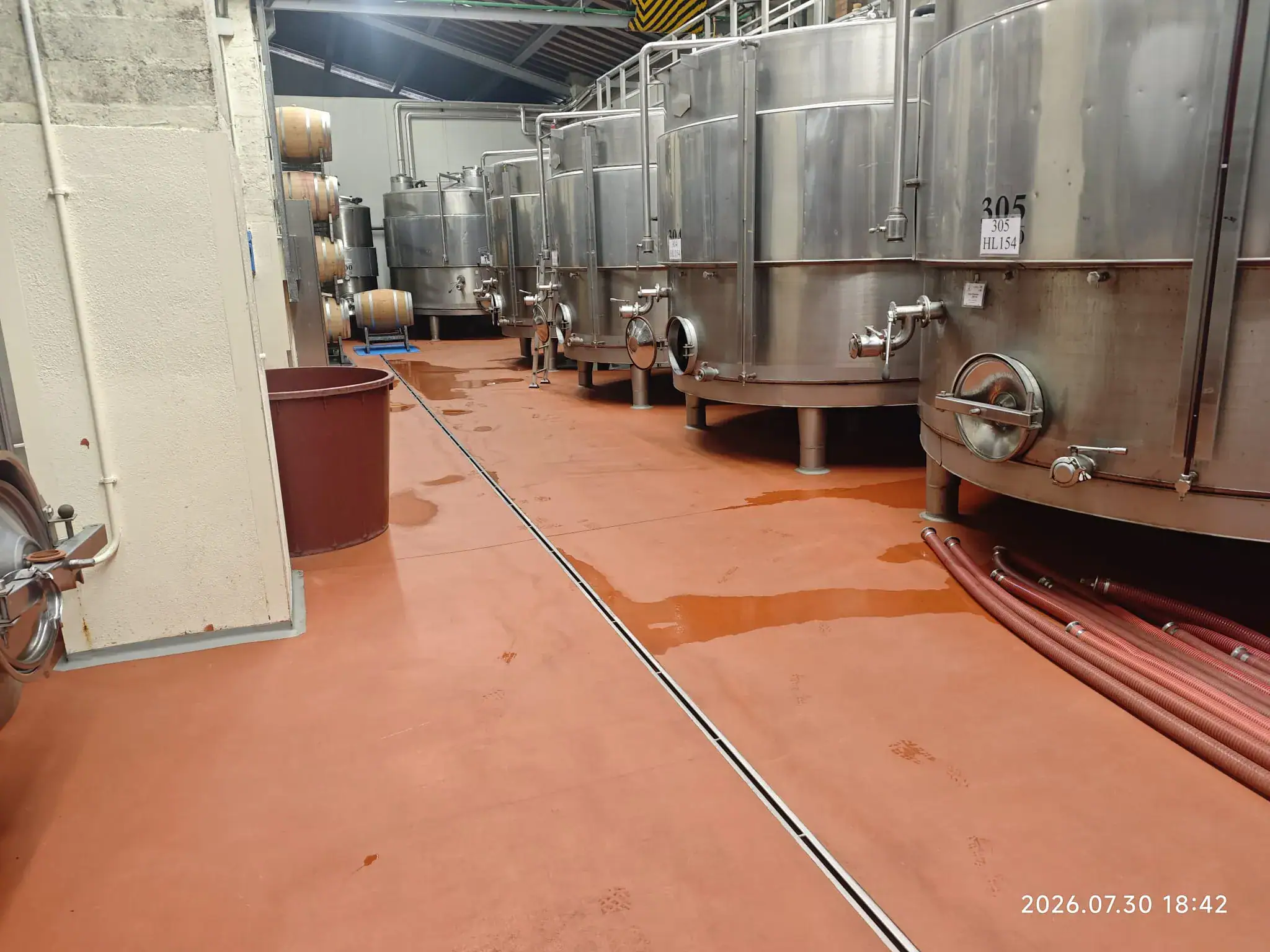Sala vasche in acciaio inox con pavimento in resina rossa Mapefloor CPU, cantina Col d'Orcia Montalcino