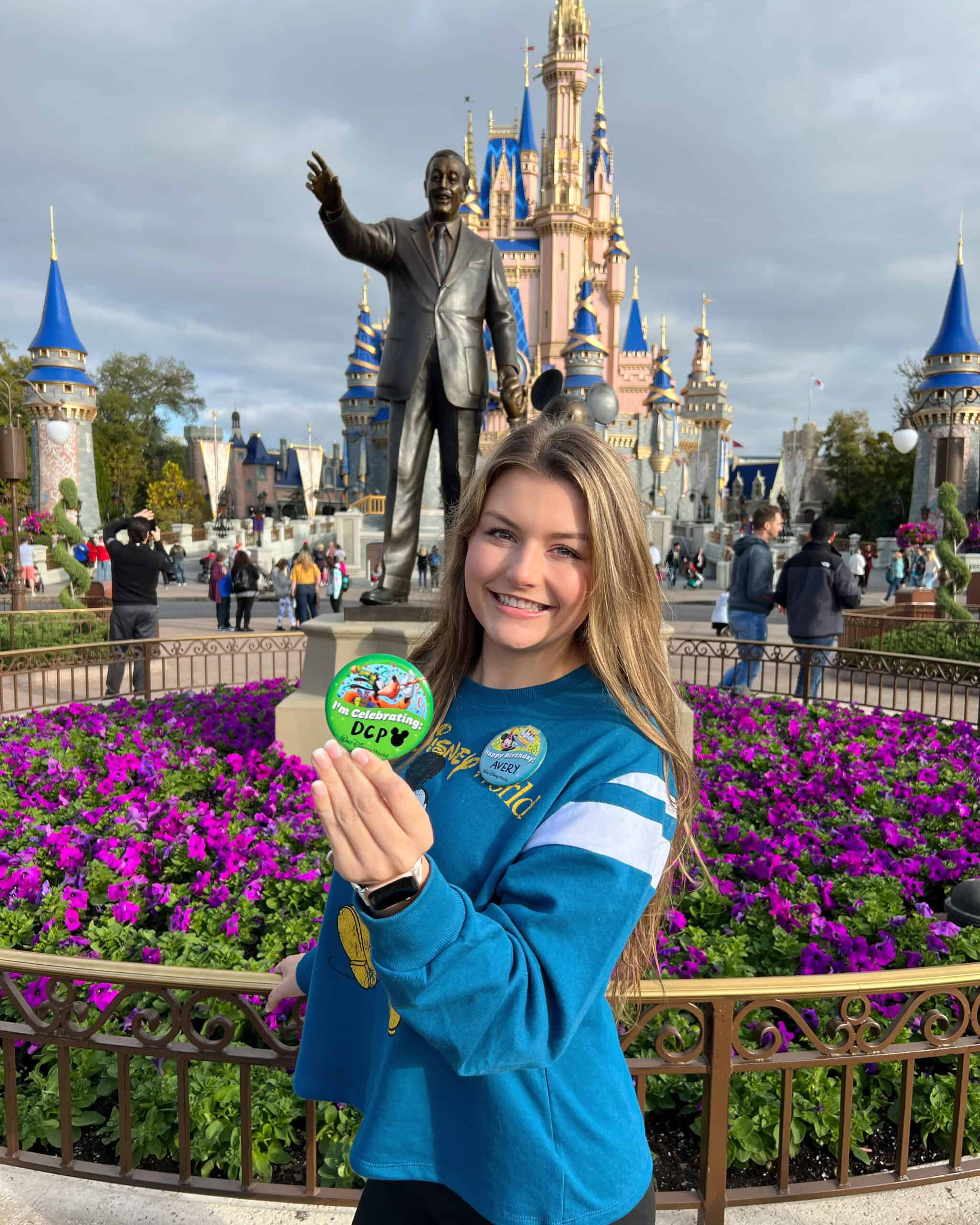 Disney World castle and a smiling woman holding a celebration button at the park.