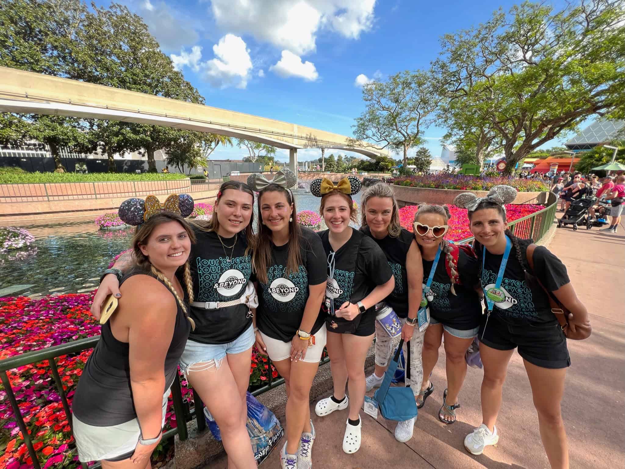 Vibrant group of friends enjoying a Disney theme park, wearing Mickey Mouse ears and matching shirts.