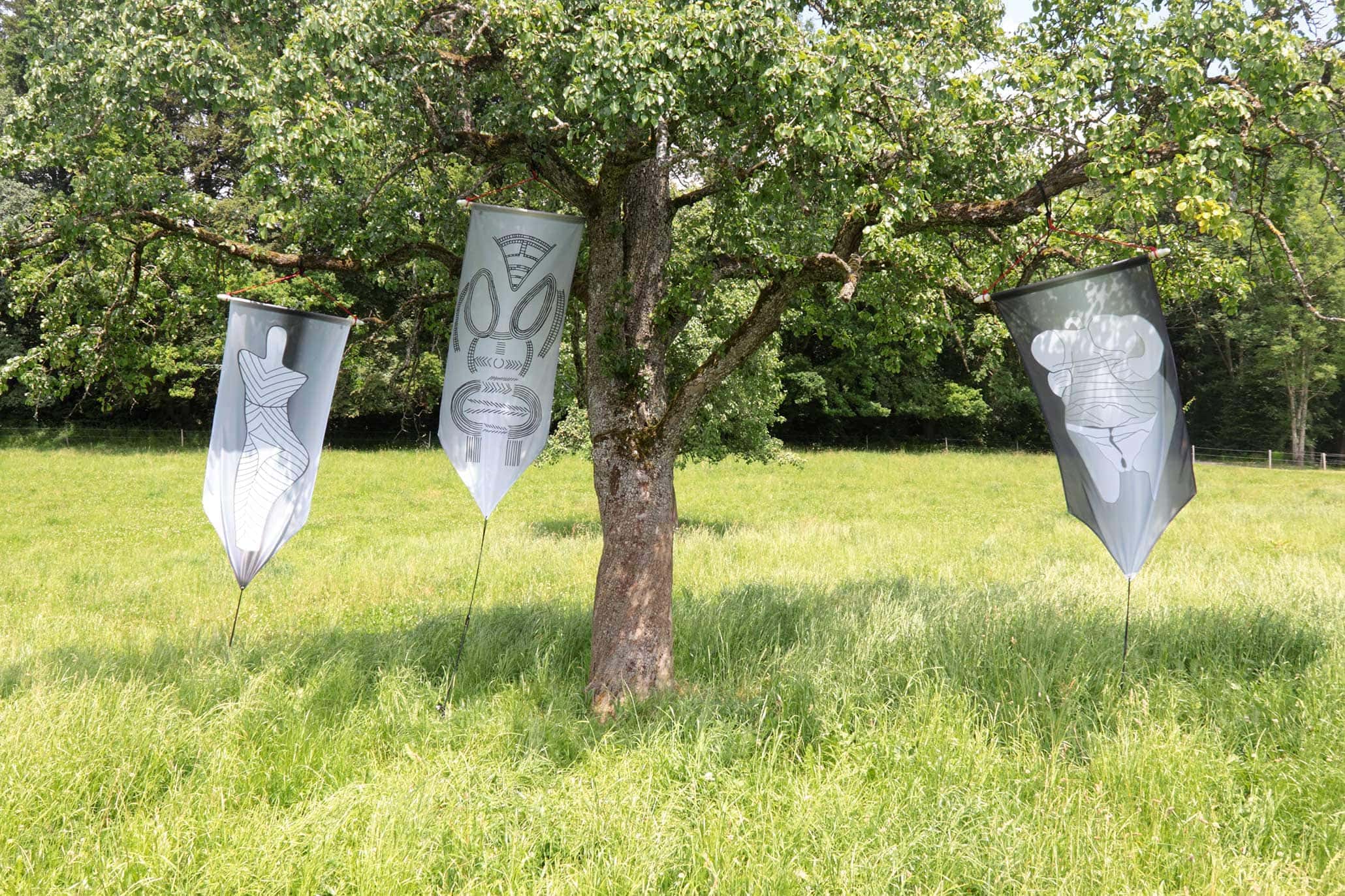Open Air exhibition along a walking path above Lake Zurich, Meilen, Switzerland, 2014. 3 GLOBAL VULVA FLAGS at a tree.